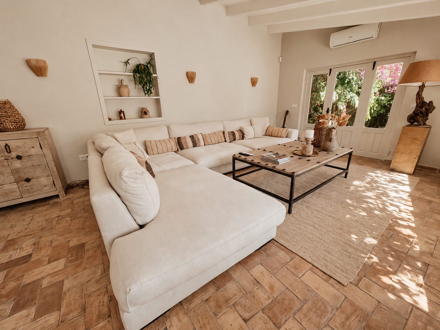 Woonkamer met terracotta vloer en openslaande deuren